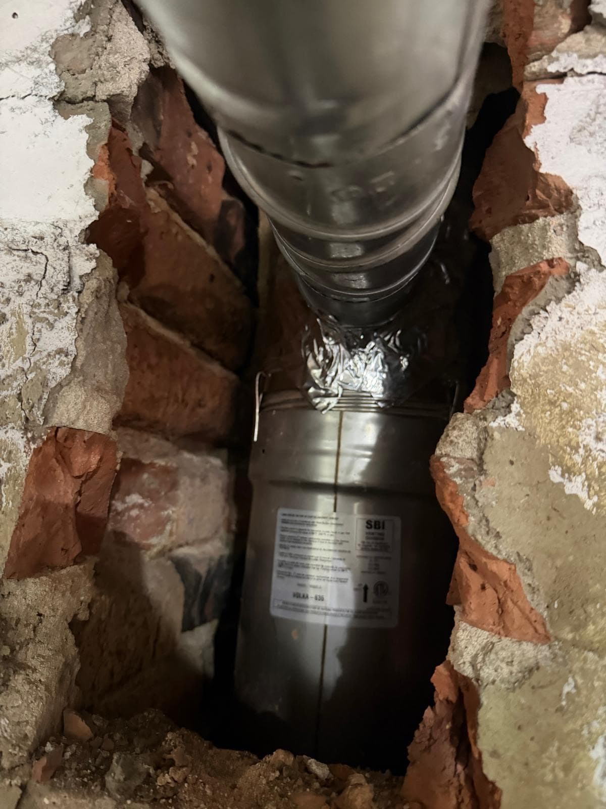 Stainless steel chimney liner connected to a heating appliance in a basement in Massachusetts